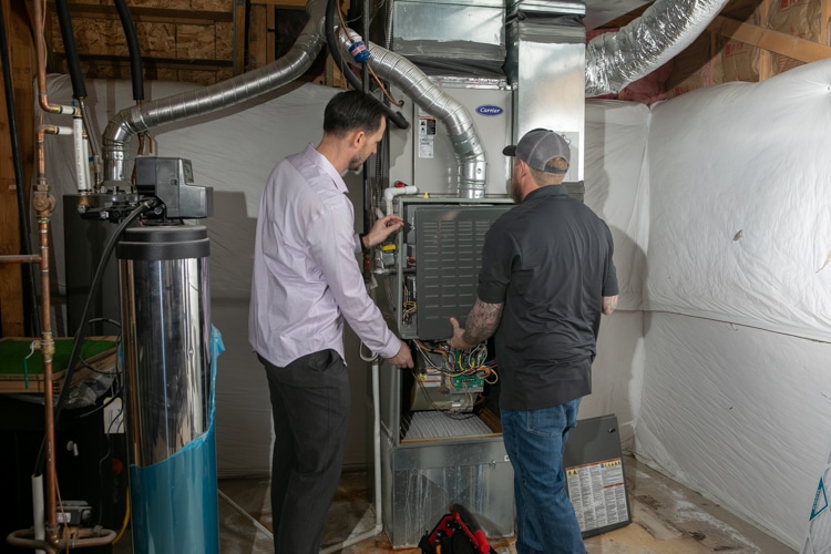 HVAC technician and male customer checking a furnance