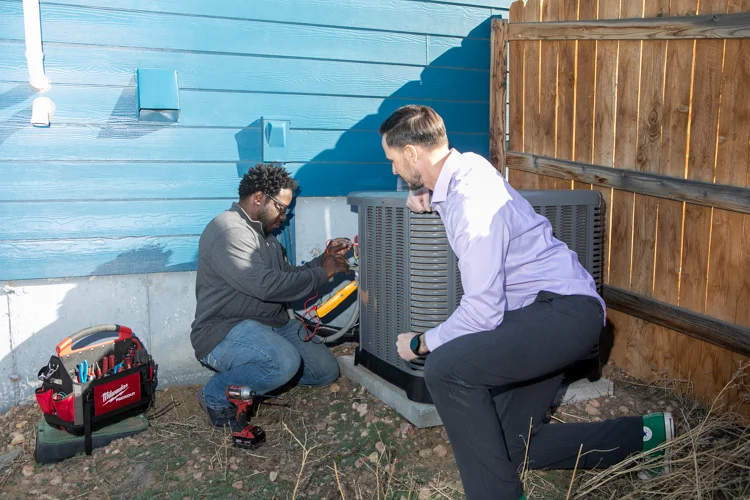 HVAC technician test an air condition unit while the customer watches